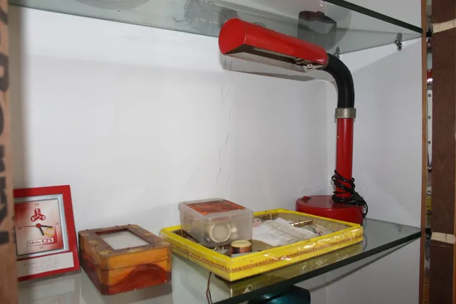 Photograph 12 of 28 from Thakur Ramsingh Ji's personal archive: his belongings and memorabilia on display shelves.