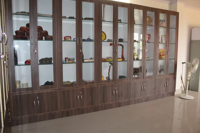Photograph 28 of 28 from Thakur Ramsingh Ji's personal archive: his belongings and memorabilia on display shelves.